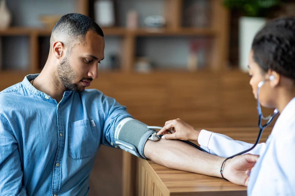 Patient's blood pressure being checked at an HIV clinic in Detroit