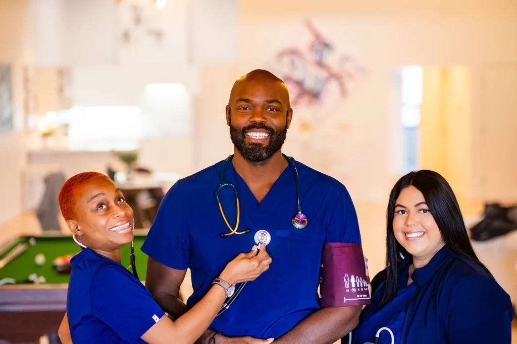 Black male clinician with black women on the right and a mixed race person on the left.